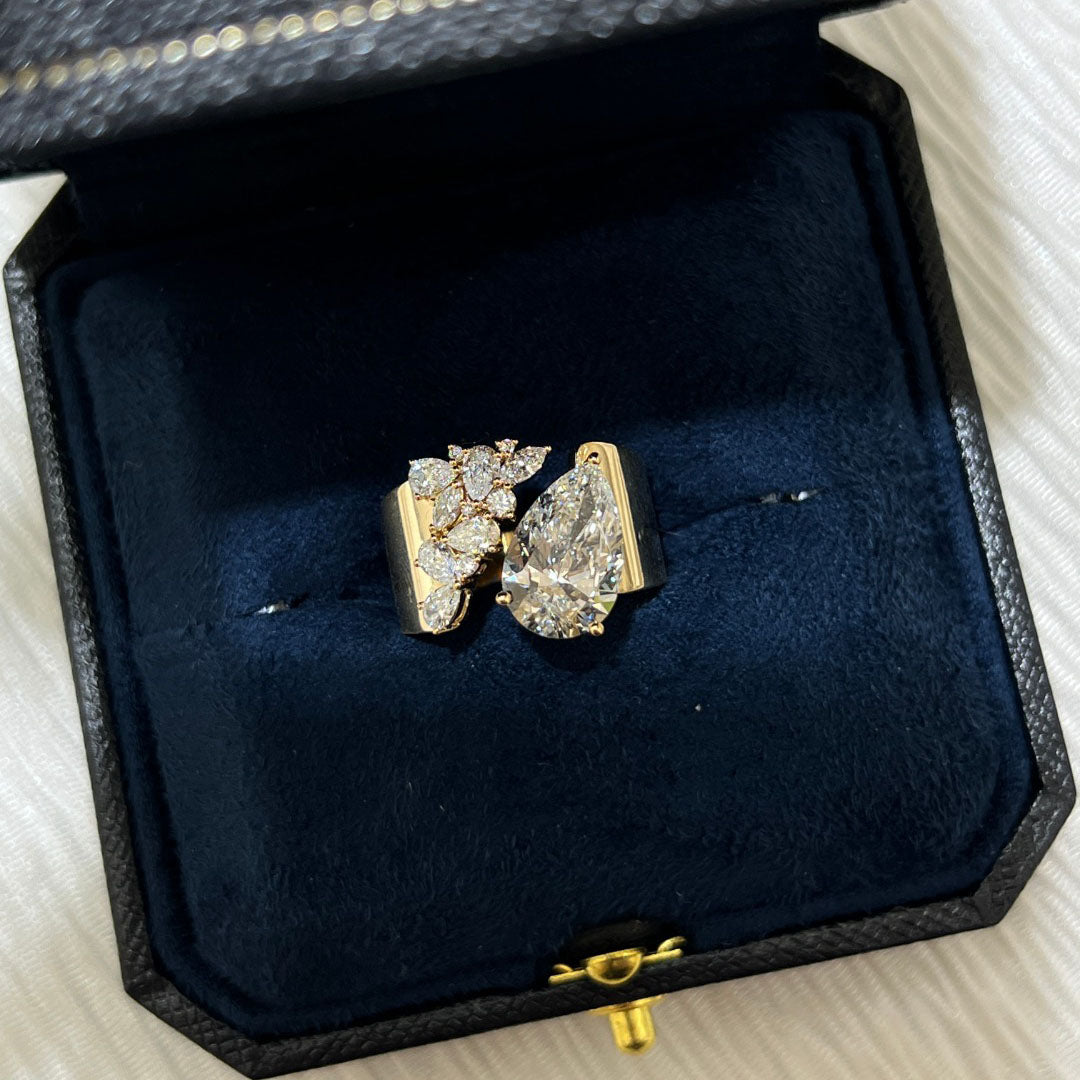 3.03-carat lab diamond as the center stone | accompanied by pear-shaped, marquise, and round small diamonds | set on an ultra-wide band | surrounded by pavé-set small diamonds | spectacular and luxurious | 18k gold