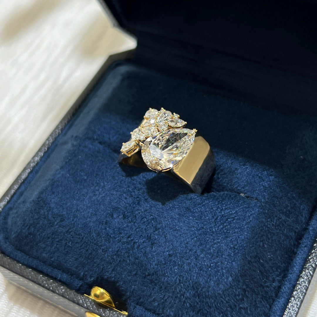3.03-carat lab diamond as the center stone | accompanied by pear-shaped, marquise, and round small diamonds | set on an ultra-wide band | surrounded by pavé-set small diamonds | spectacular and luxurious | 18k gold